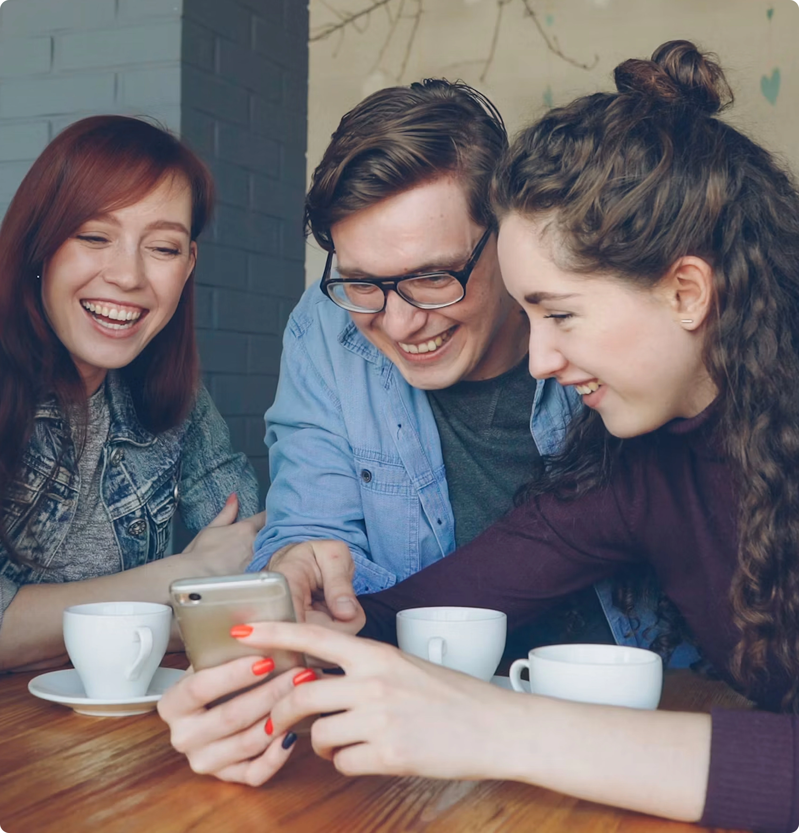 Venner der smiler sammen omkring en telefon